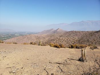 Scenic view of desert against clear blue sky