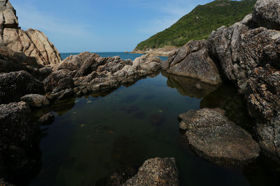 Rock formation in sea against sky