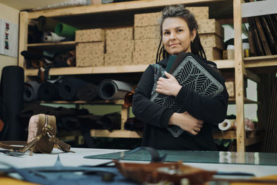 Tailoring eco leather laptop cases. woman designer posing with eco leather textile product at her