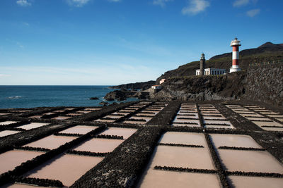 Agricultural field and lighthouses at la palma against sky