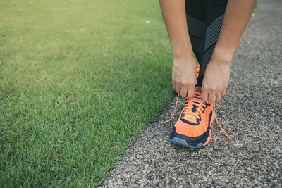 Low section of person wearing shoes on field