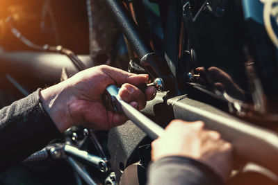 Cropped hands of mechanic repairing motorcycle