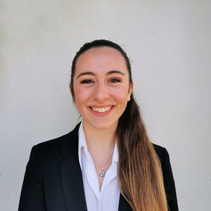 Portrait of a smiling young woman against wall