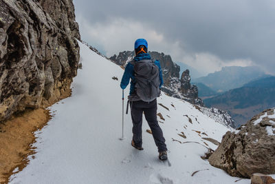 Rear view of man skiing on snow covered mountain