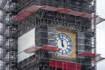 Low angle view of clock tower against building in city