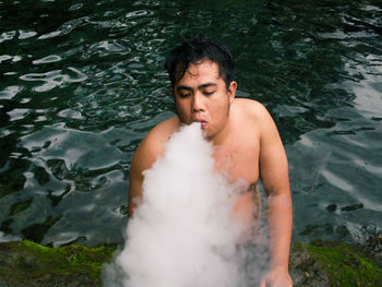 Young man blowing smoke