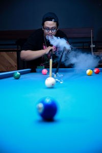 Midsection of woman playing pool