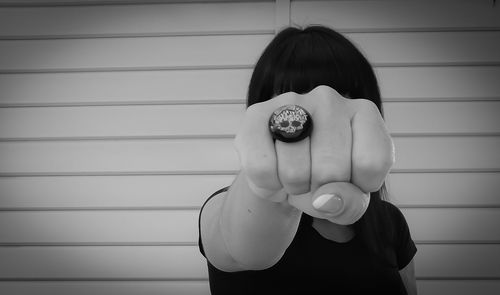 Portrait of woman standing against wall