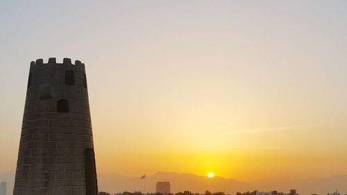 Low angle view of silhouette buildings against sky during sunset