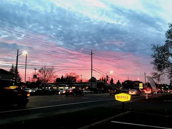 Cars on road against sky in city