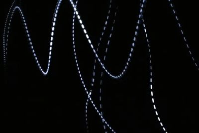 Close-up of illuminated lighting equipment against black background