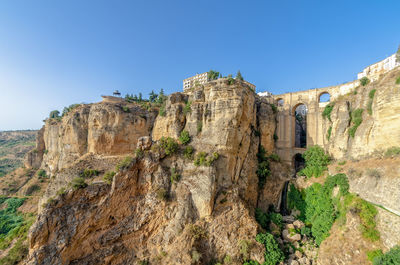 Low angle view of rock formations against clear blue sky