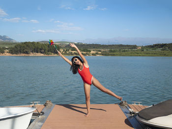 Rear view of woman with arms raised in sea