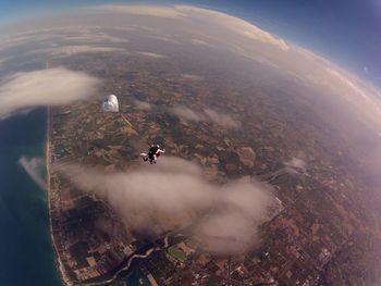 Aerial view of people paragliding over landscape