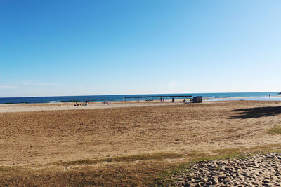 Scenic view of beach against clear blue sky