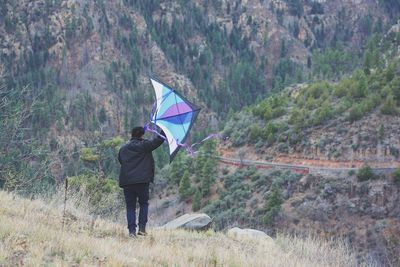 Rear view of man with umbrella walking on rainy day