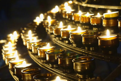 Close-up of candles burning in illuminated building