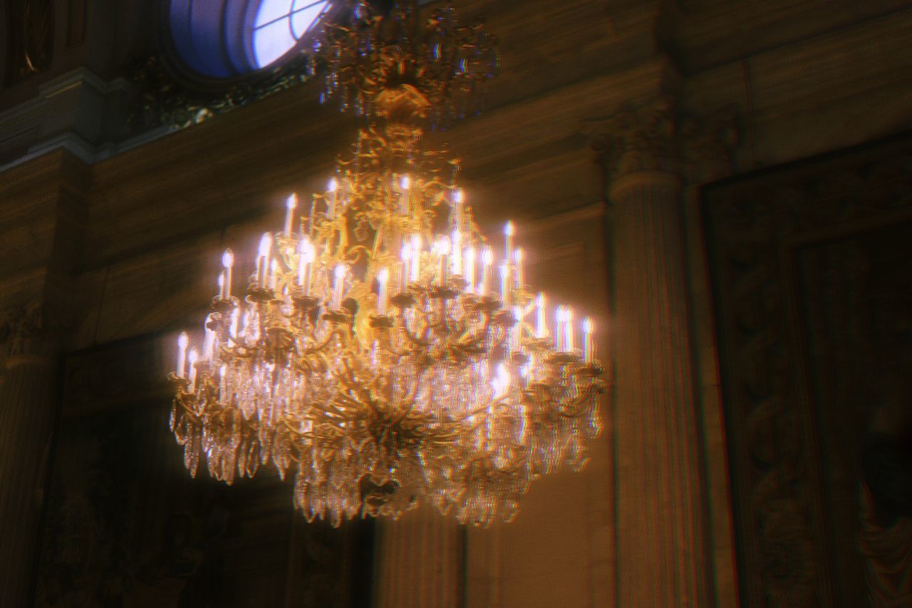 LOW ANGLE VIEW OF ILLUMINATED CHANDELIER HANGING ON BUILDING
