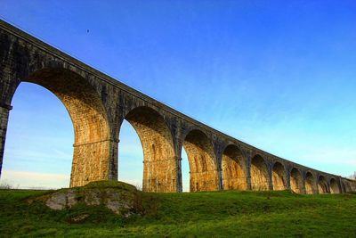 Low angle view of bridge against blue sky