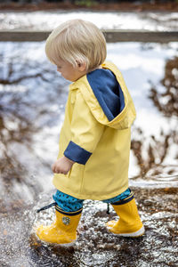 Rear view of boy playing with water