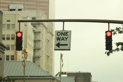 Road sign against sky in city