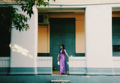 Full length of woman standing against building