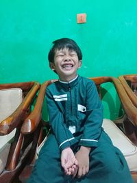 Portrait of smiling boy sitting on seat