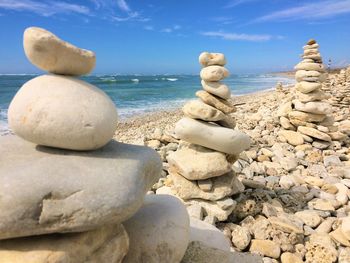 Stack of stones on beach against sky