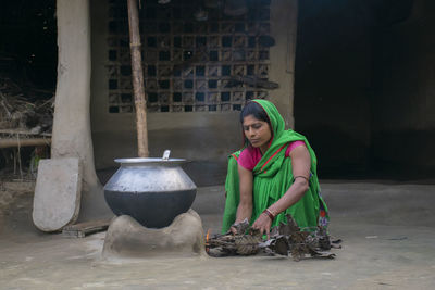 Indian woman making food on traditional chulha or stove