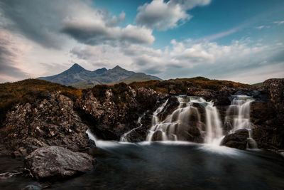 Scenic view of waterfall against sky