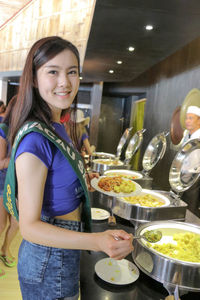 Portrait of smiling young woman having food