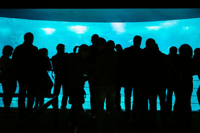 Silhouette people at music concert against sky