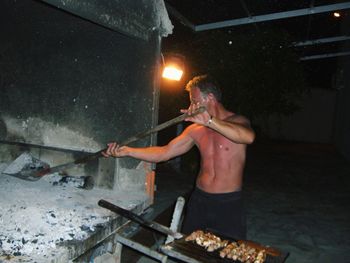 Shirtless man working in kitchen
