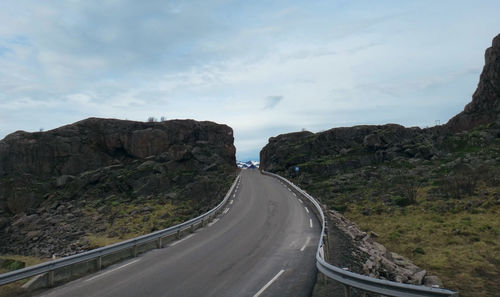 Road leading towards mountains against sky