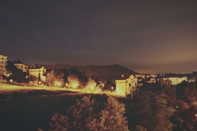 Houses against mountain range at night