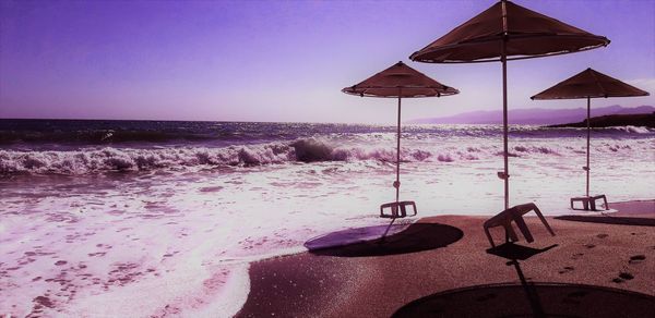Beach umbrella by sea against sky