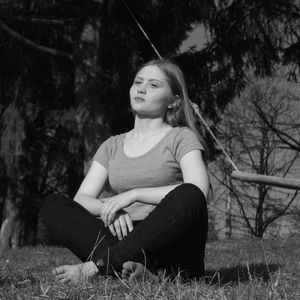 Full length of teenage girl sitting on land