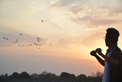 Young man against sky during sunset