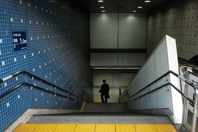 Rear view of man walking in subway