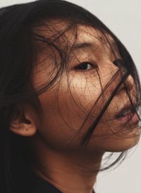 Close-up of beautiful young woman against white background