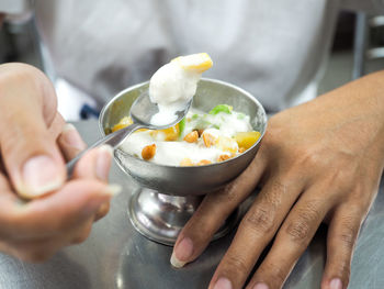 Midsection of man preparing food in bowl on table