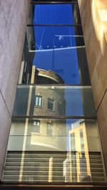 Low angle view of modern building against blue sky