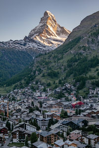 Aerial view of townscape and mountains against sky