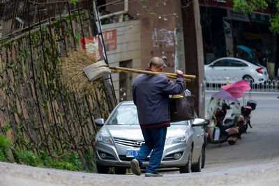 Rear view of man riding motorcycle on street