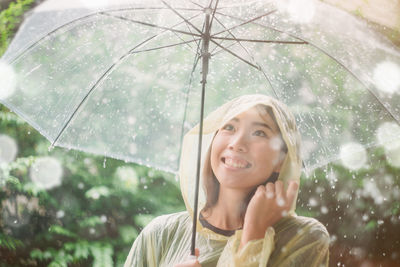 Portrait of a smiling young woman in rain