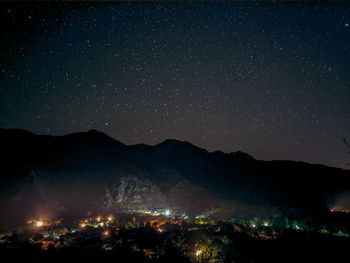 Scenic view of illuminated mountains against sky at night