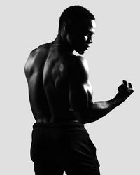Rear view of shirtless man standing against white background