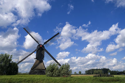 Traditional windmill on field against sky