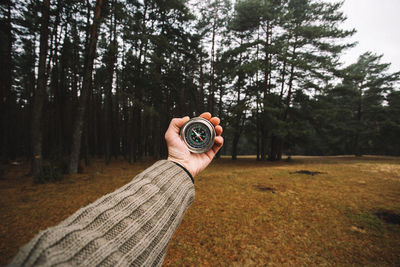 Midsection of man photographing in forest