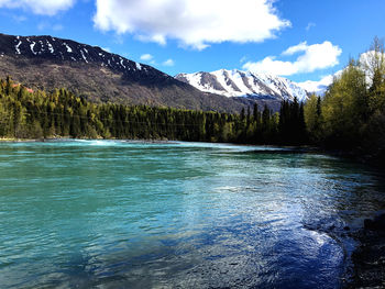 Scenic view of lake by mountains against sky